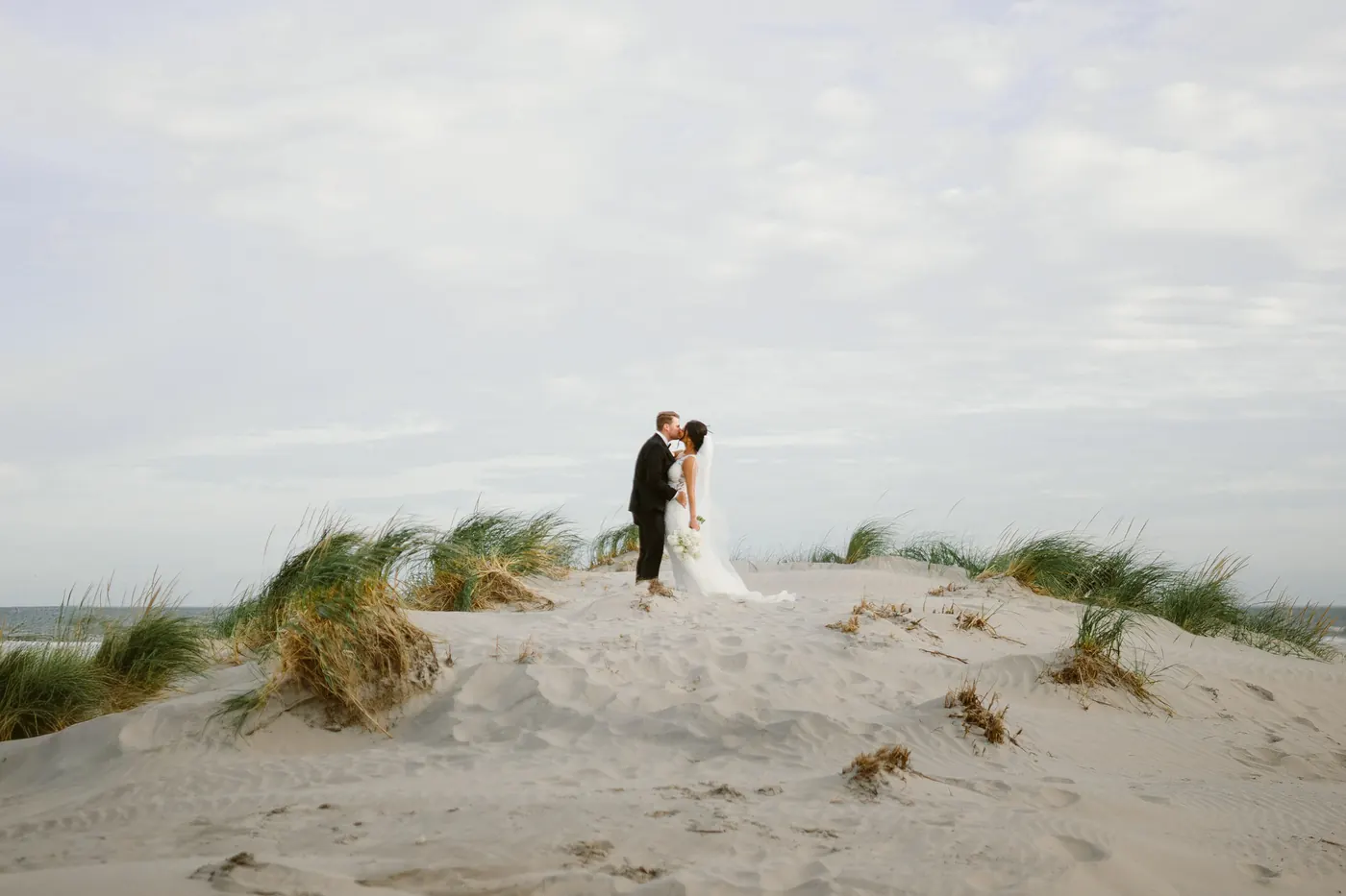 Mason and Morgan kissing on top of a sand dune at ICONA Diamond Beach