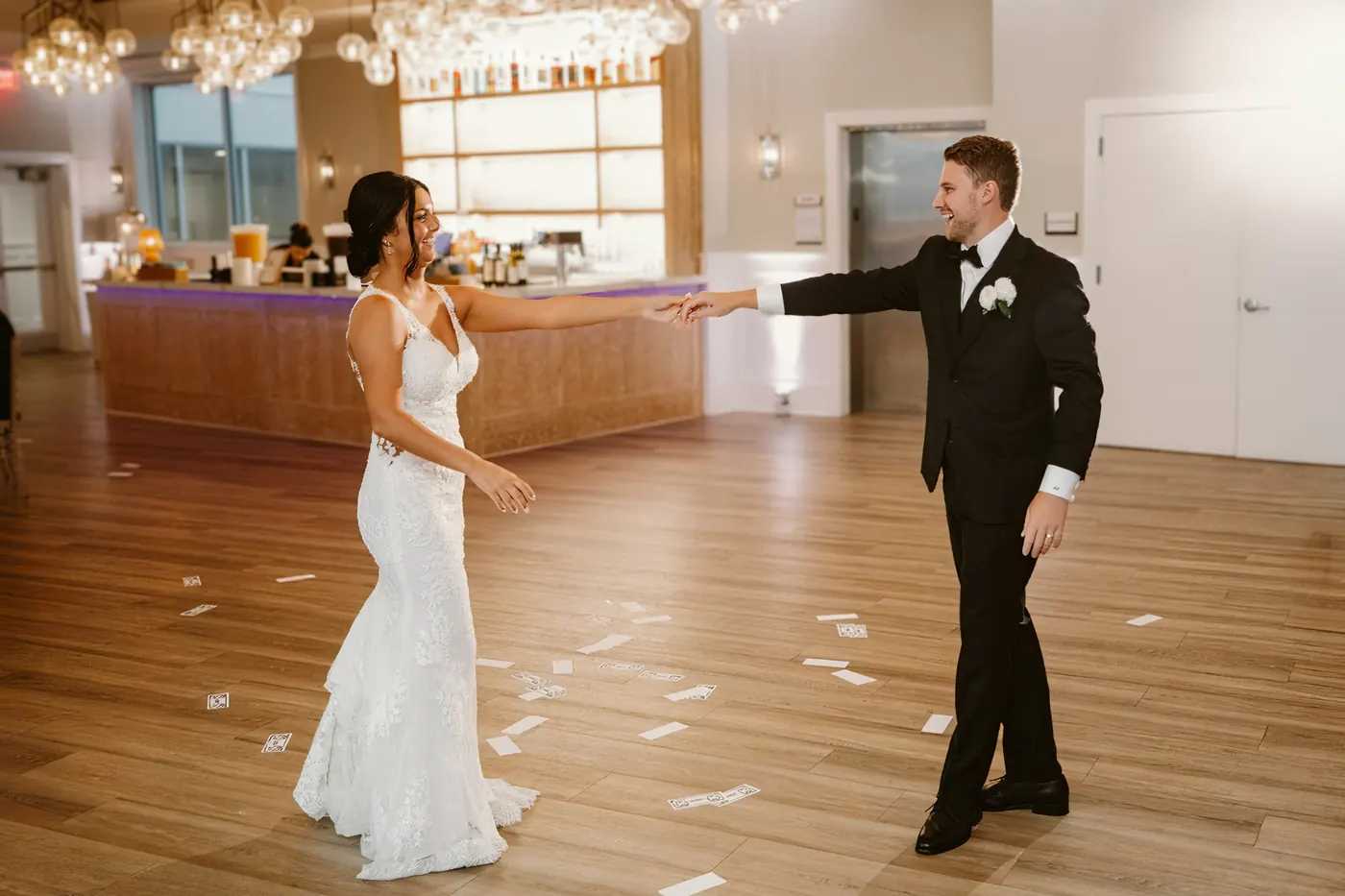 Mason reaching for Morgan's hand as their first dance begins
