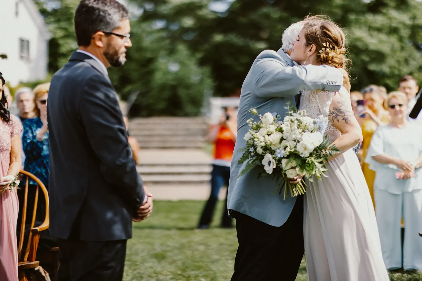 Erica's father hugging her at the end of the aisle beside Matt at Johnson's Locust Hall Farm in Jobstown, NJ