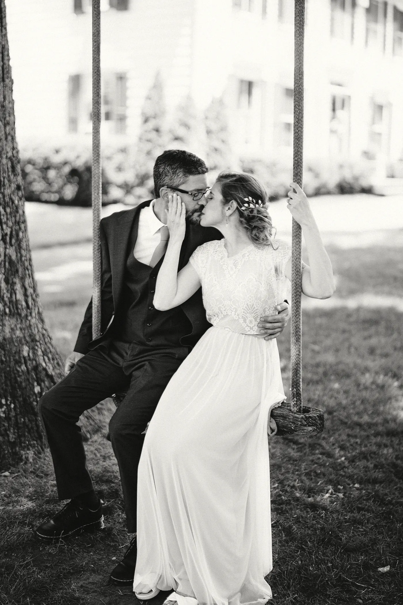 Black and white photo of Matt and Erica kissing on a rope swing at Johnson's Locust Hall Farm in Jobstown, NJ