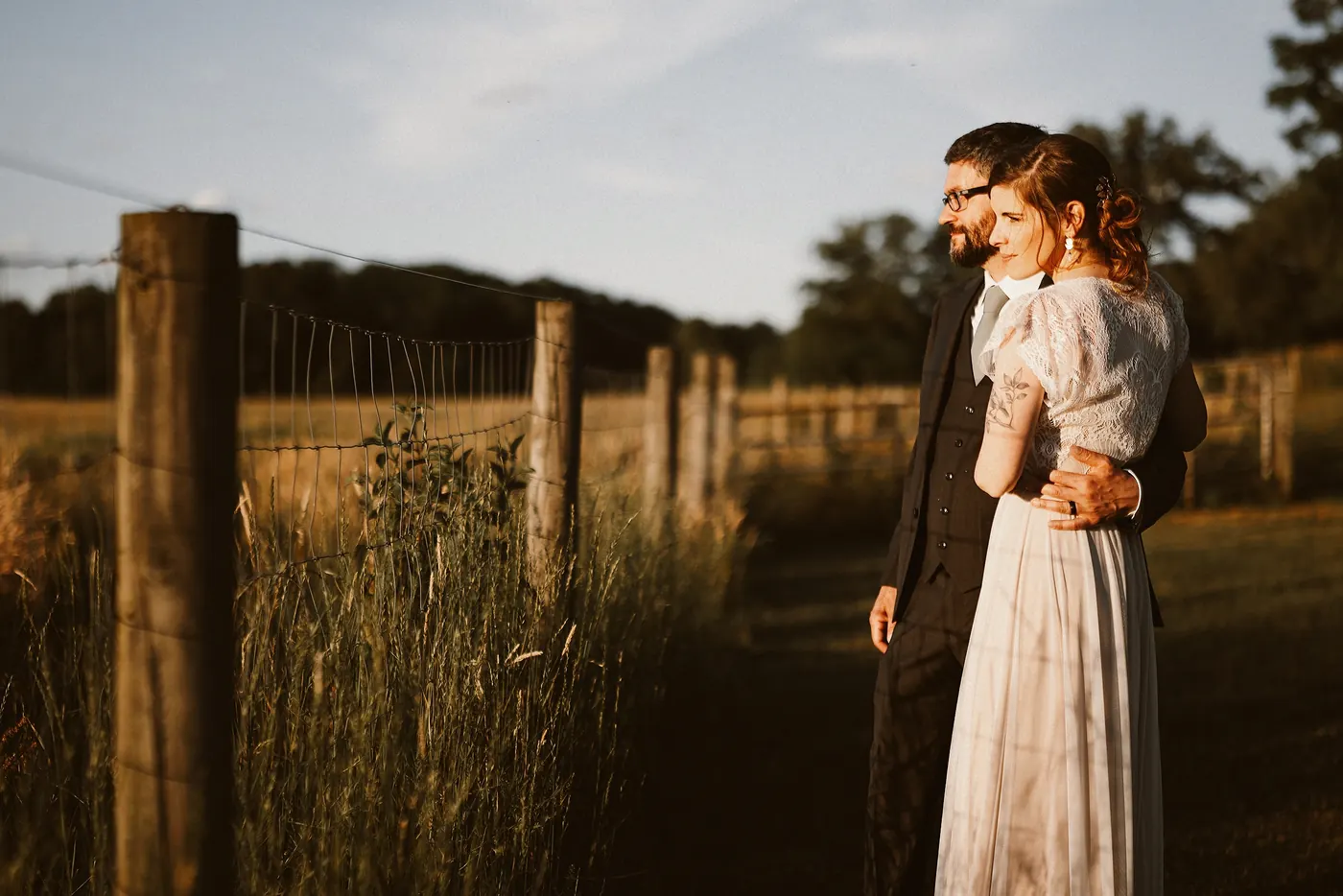 Matt hugging Erica from behind by the old fence posts at sunset at Johnson's Locust Hall Farm in Jobstown, NJ