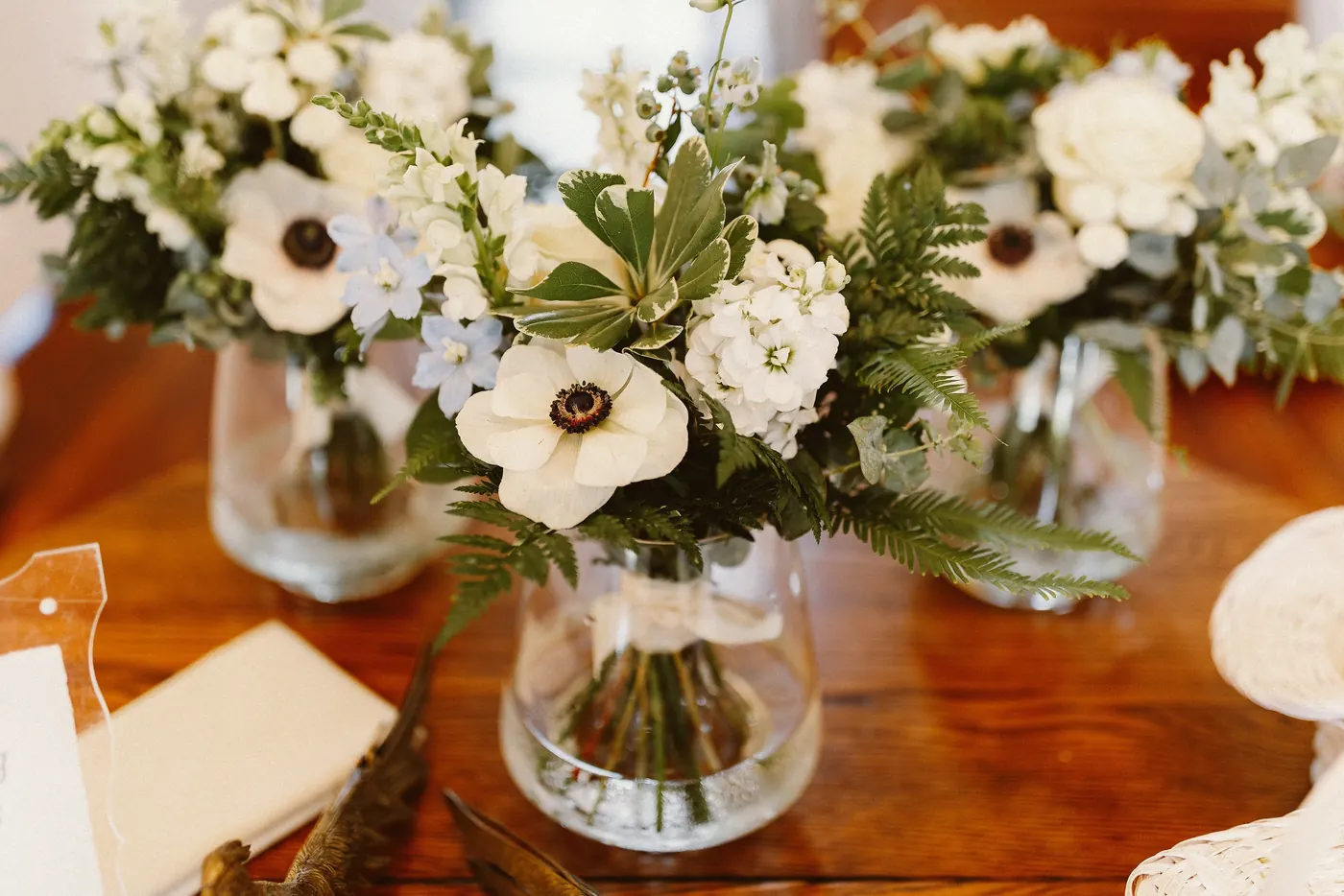 White anemone and greenery centerpieces in glass vases at Johnson's Locust Hall Farm in Jobstown, NJ