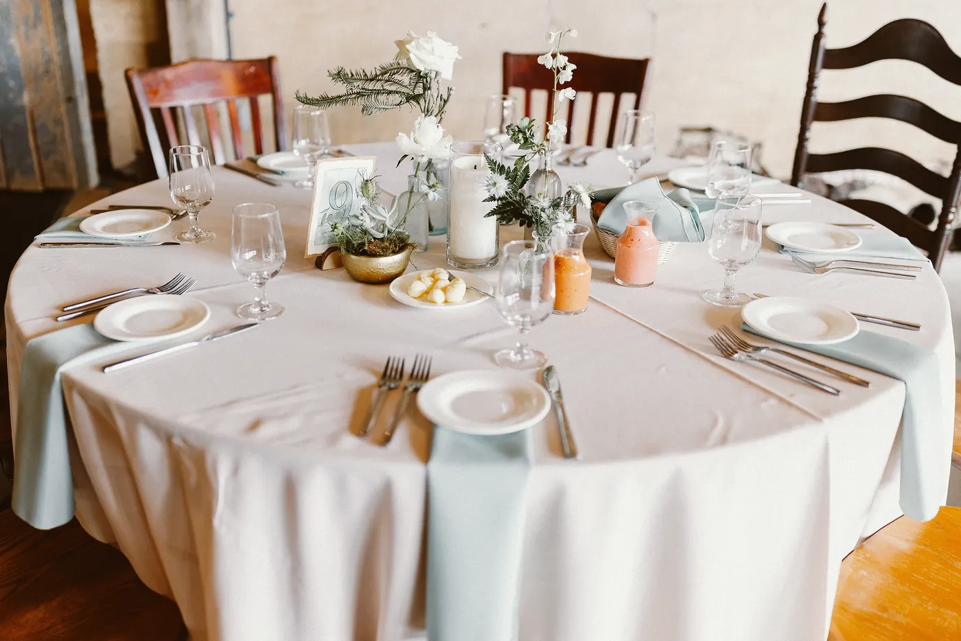 A round reception table set with soft blue napkins and white flowers at Johnson's Locust Hall Farm in Jobstown, NJ