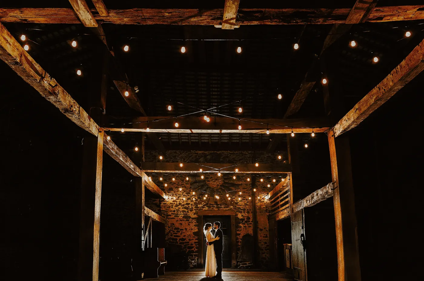 Matt and Erica sharing a last dance under the string lights in the barn at Johnson's Locust Hall Farm in Jobstown, NJ