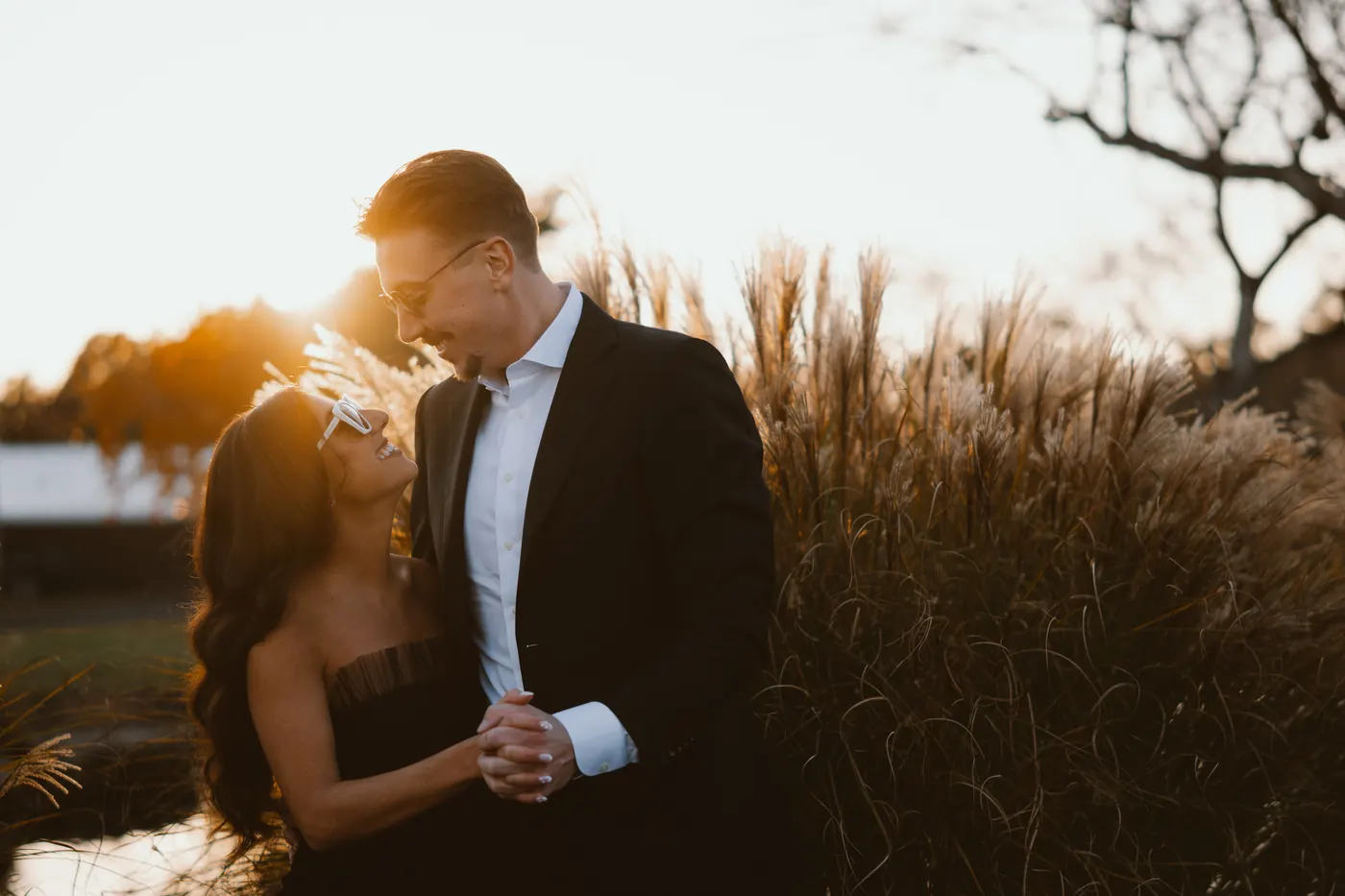 Morgan and Will dancing close in warm golden light beside the tall grass at Renault Winery in Egg Harbor City, NJ