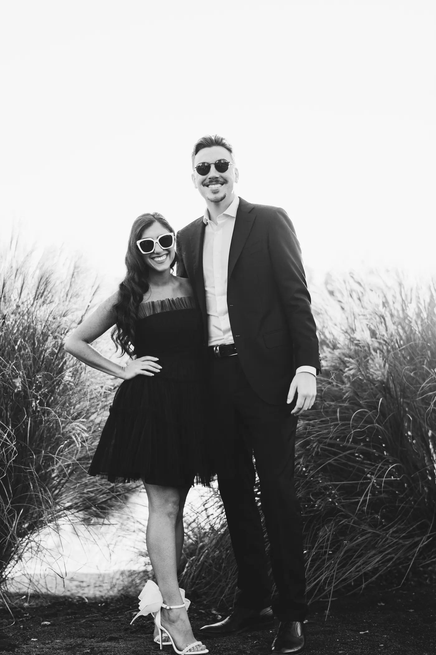Full-length portrait of Morgan and Will in sunglasses beside the tall grass at Renault Winery in Egg Harbor City, NJ