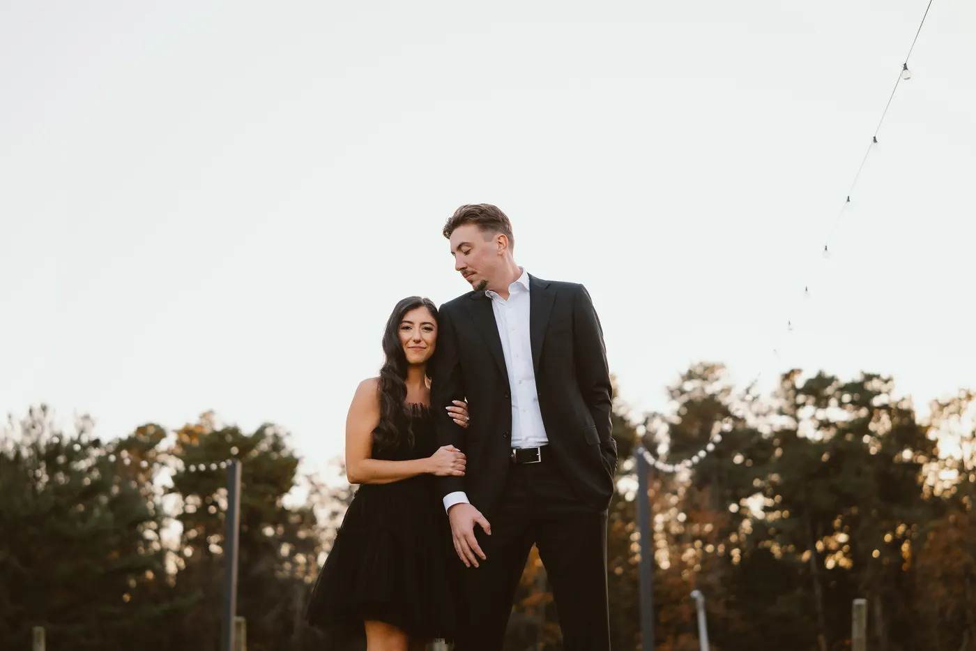 Morgan and Will on the lawn at dusk under string lights at Renault Winery in Egg Harbor City, NJ
