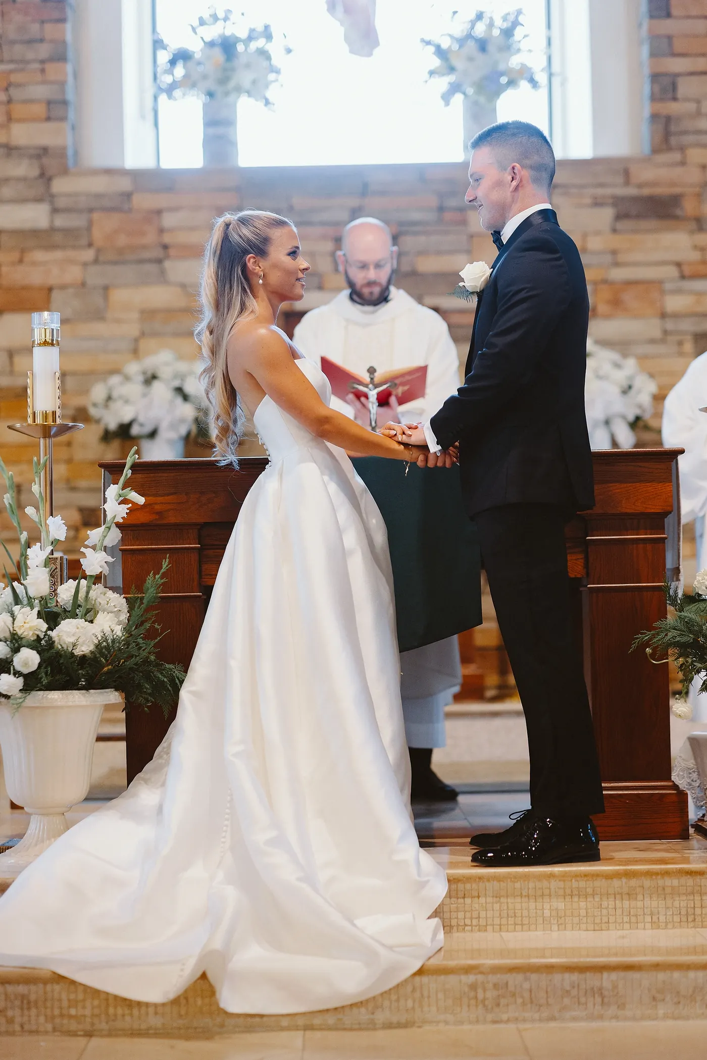Steve and Madison holding hands during their vows at Saint Charles Borromeo Church in Cinnaminson, NJ