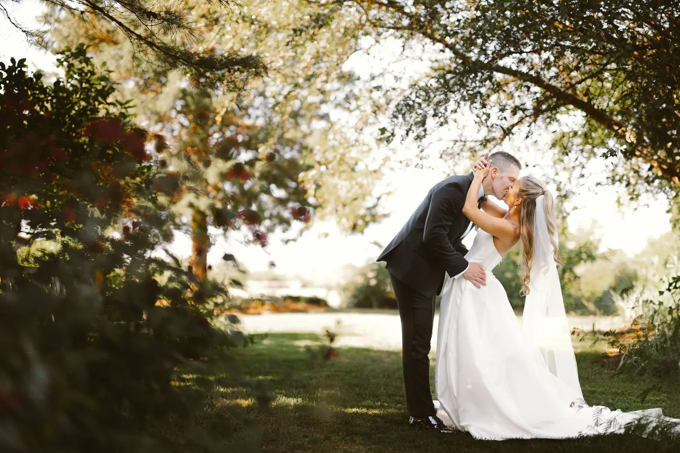 Steve and Madison embracing in the shade of the trees