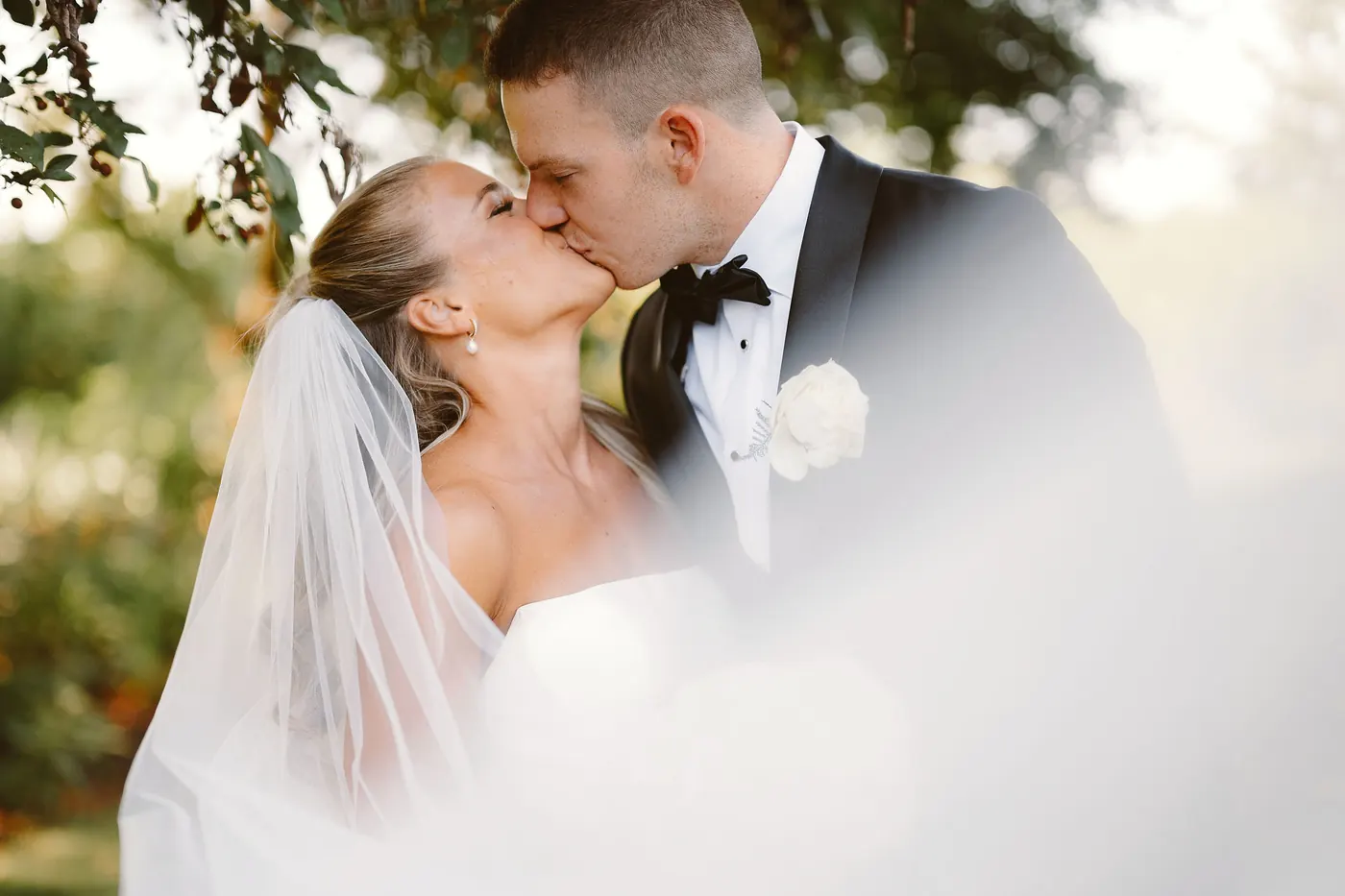 Steve kissing Madison's cheek with her veil drifting between them