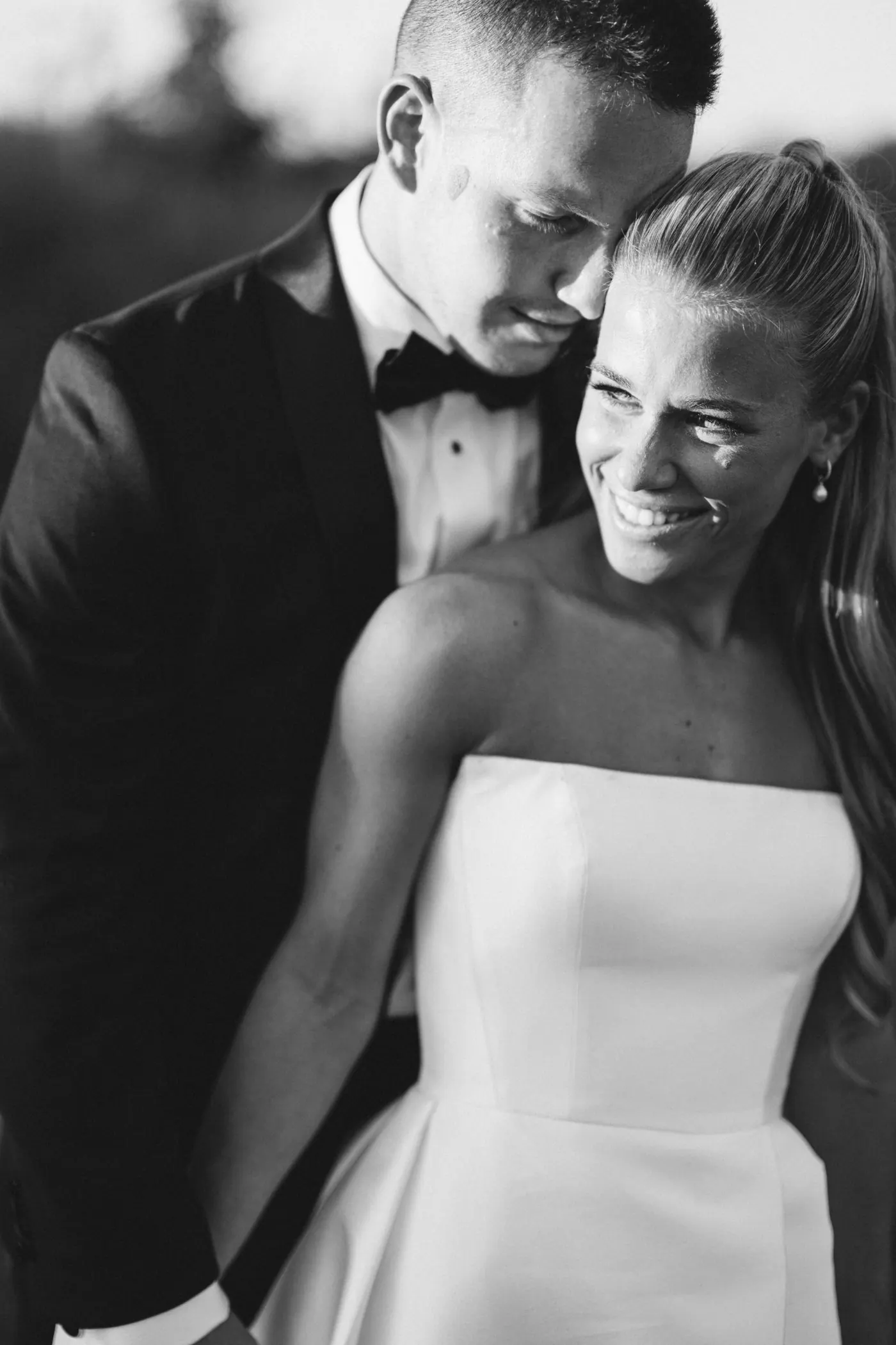 Madison laughing as Steve holds her close, in black and white