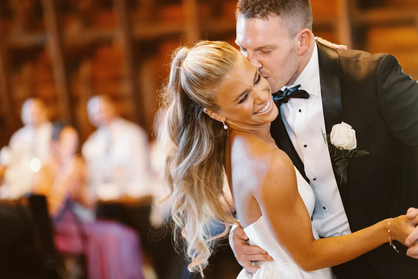 Madison laughing as Steve kisses her cheek on the dance floor