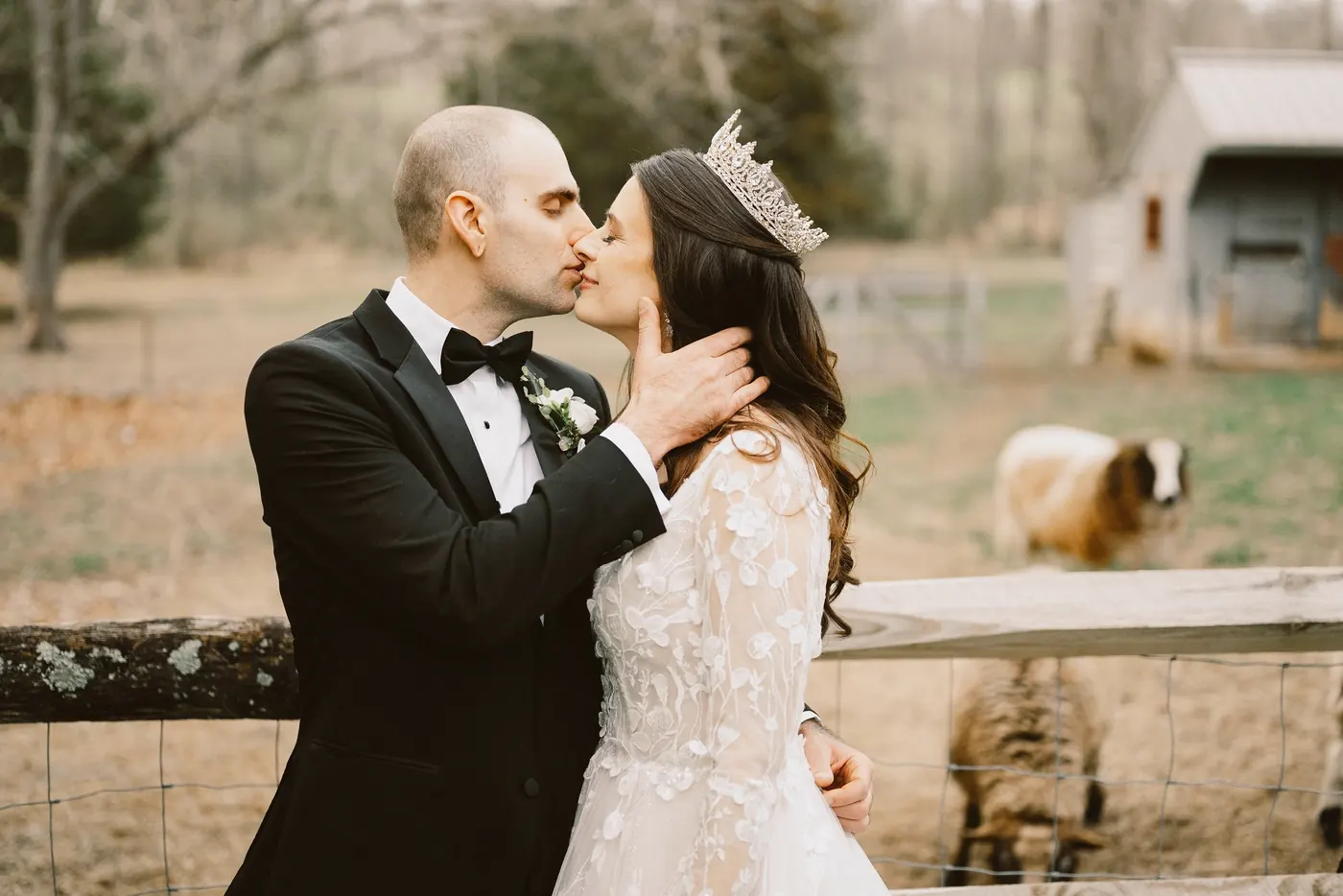 Steve and Maria kissing by the fence of the sheep pasture