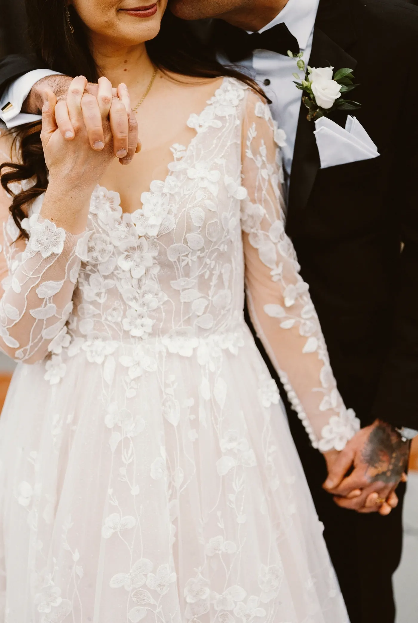 Close-up of Steve and Maria's hands and her floral lace sleeves