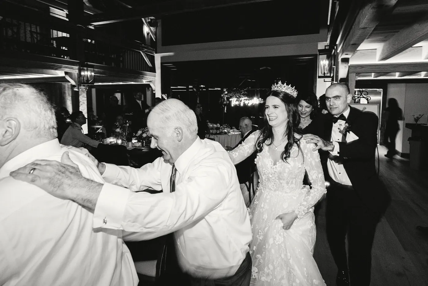 Maria dancing with family on the dance floor, in black and white