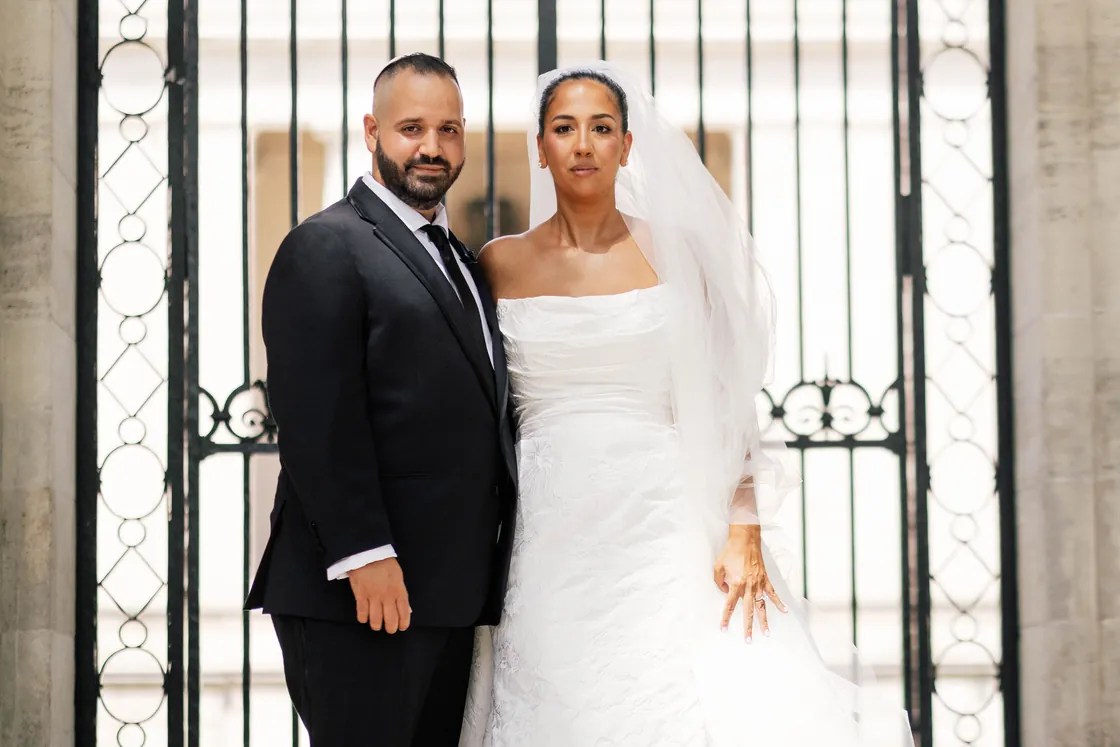 Gianna and Simon standing together in front of the iron gates of the Rodin Museum in Philadelphia on their Union Trust wedding day